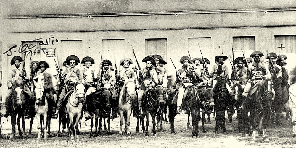 Vários homens armados e montados a cavalo