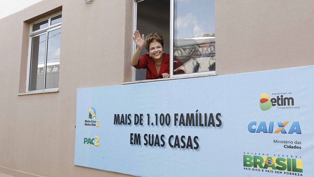 Dilma Roussef em janela de apartamento acenando