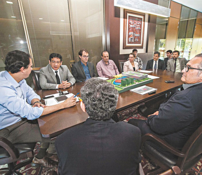 Camilo Santana sentado ao redor de mesa durante reunião com outras autoridades.