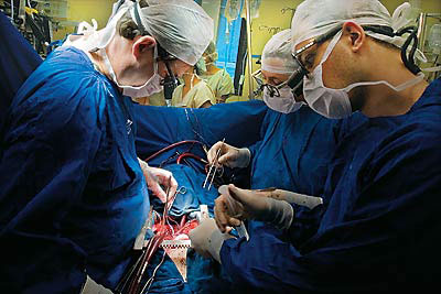 Três médicos efetuando cirurgia