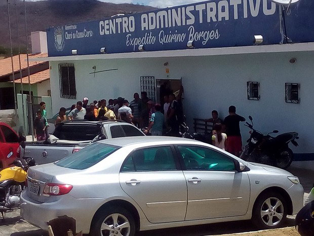 Fachada da Prefeitura de Choró com populares na porta de entrada e carros estacionados em frete