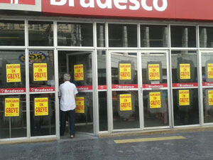 Fachada dos bancos com cartazes contendo os letreiro: Bancários em Greve