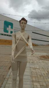 Manequim com várias faixas pelo corpo em frente ao Hospital Regional do Sertão Central