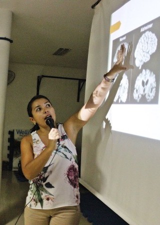Mulher falando ao microfone durante apresentação de slide