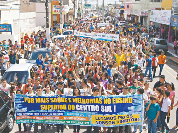 Rua da cidade de Iguatu, Ceará - tomada por pessoas segurando faixas em manifestação