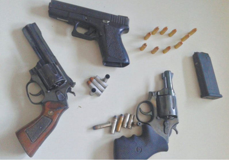 Revólveres, pistola, balas e um cartucho