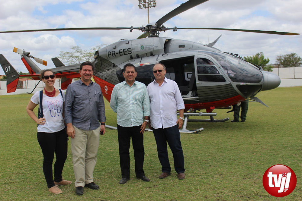 Lúcio Gomes e mais três pessoas em primeiro plano e helicóptero em segundo plano 