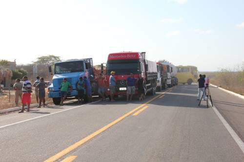 Caminhões estacionados em uma mão da rodovia.