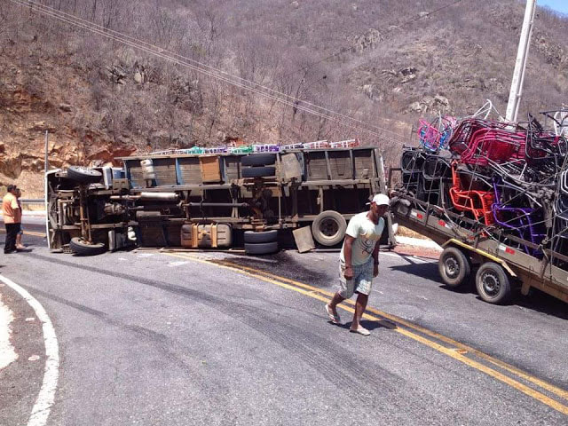 Caminhão carregado de cadeiras tombado em rodovia.