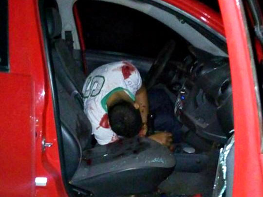 Homem dentro de carro, no banco do motorista, caído sem vida. 