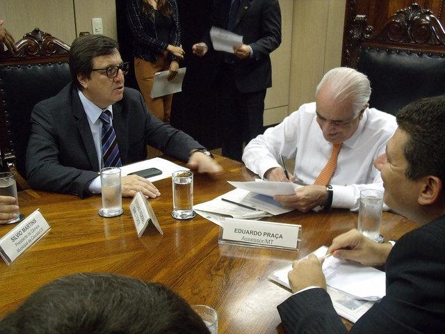 Danilo Forte sentado a mesa com Eduardo Praça e outros políticos.