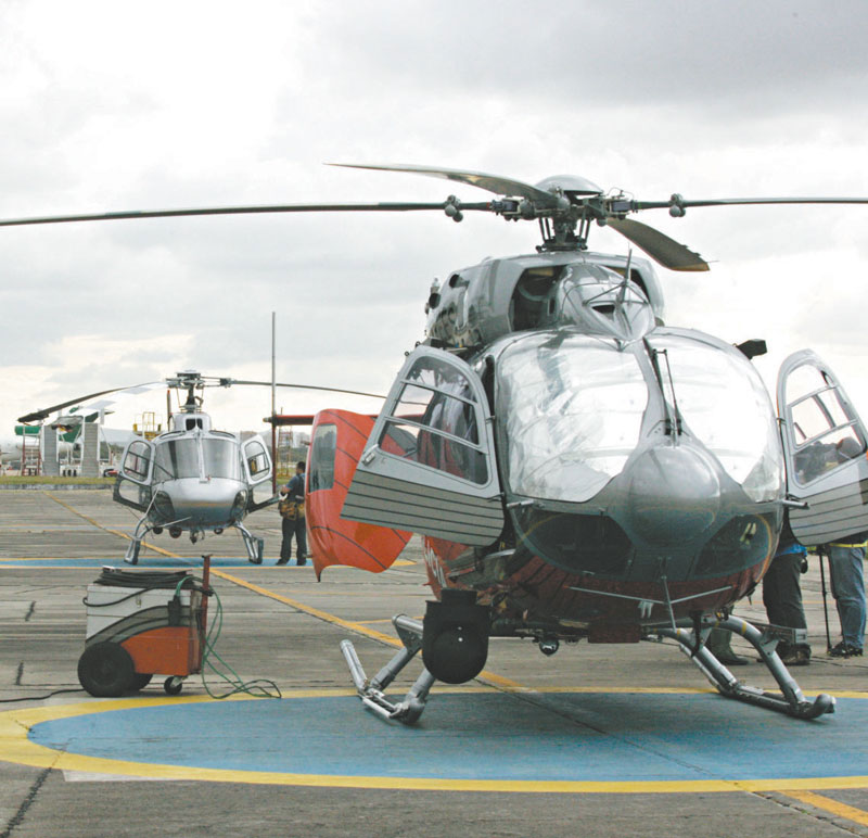 Dois helicópteros pousados com as portas abertas