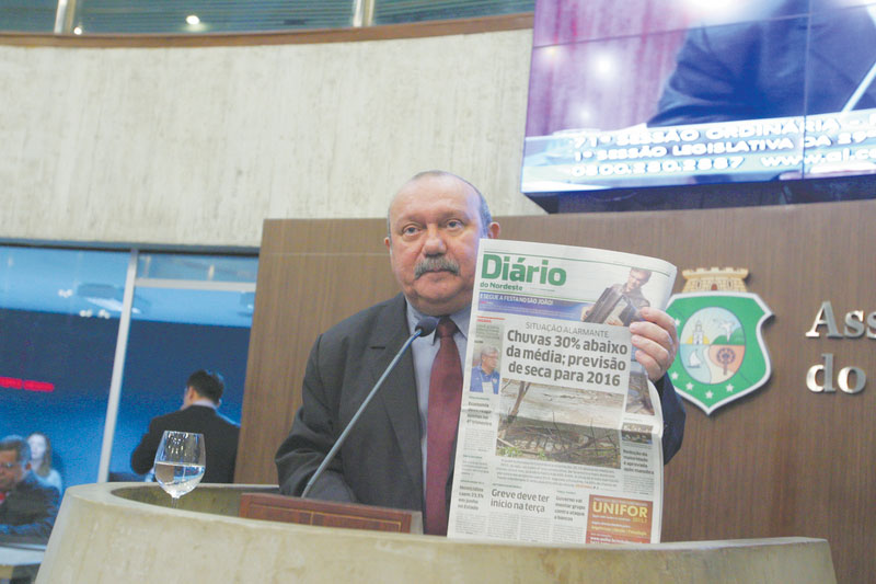 Fernando Hugo segurando jornal do Diário do Nordeste que contém o título em destaque: Chuvas 30% abaixo da média: previsão de seca para 2016