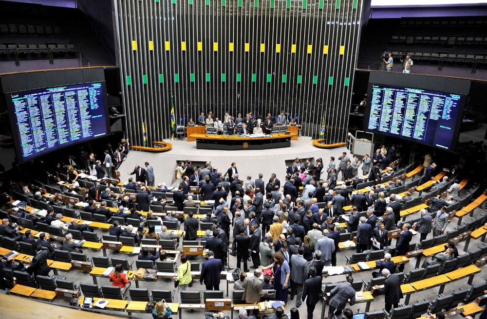 Políticos discutindo na Câmara dos Deputados com principal movimentação no corredor central