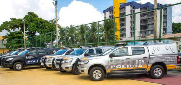 Cinco veículos policiais estacionados lado a lado.