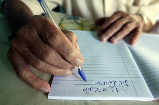 mãos idosas escrevendo em caderno