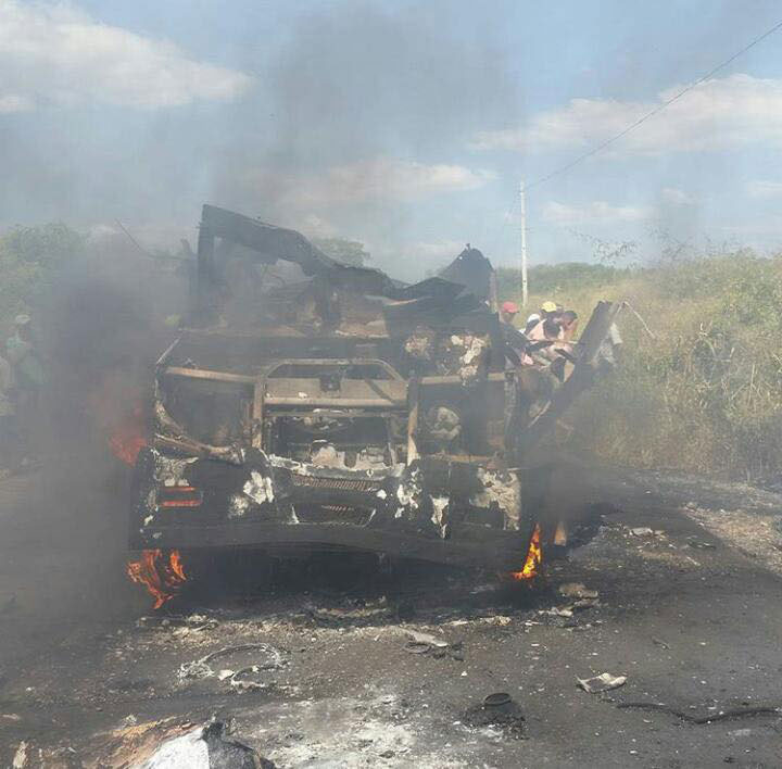 Destroços de veículo blindado ainda em chamas e com bastante fumaça