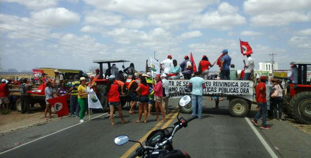 Pessoas com bandeiras e faixas bloquearam rodovia com veículos agrícolas