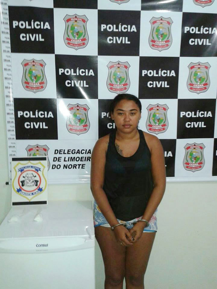 Antônia Lucineide de Lima algemada em frente a banner da Polícia Cívil de Limoeiro do Norte-CE