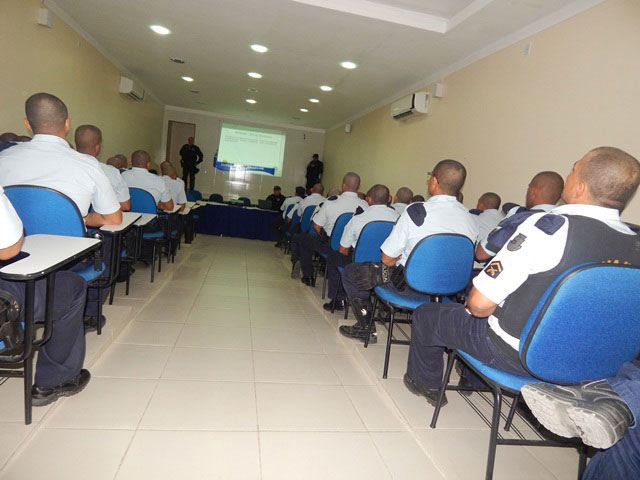 Auditório com vários policiais sentados participando de um curso