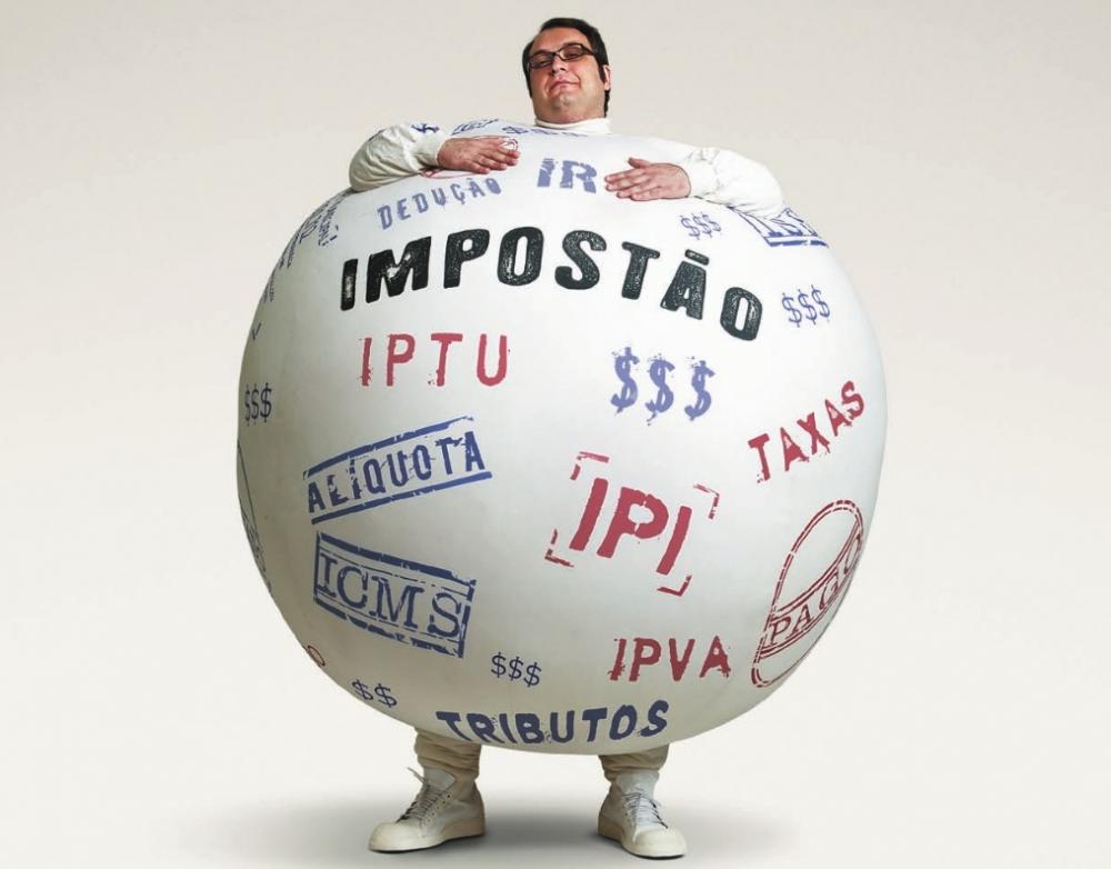 Homem trajando roupa em formato de bola com o nome de vários impostos pintados