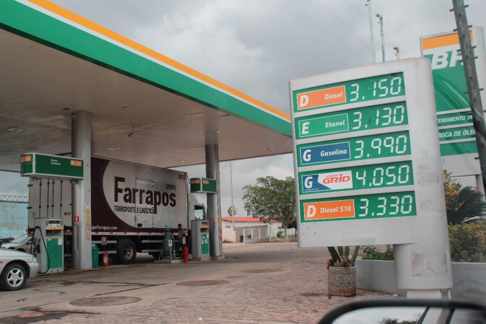 Posto de Combustível com placa contendo uma tabela de preços.