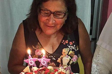 Sebastiana Maria de Lima sorrindo em frente a bolo com velas com o número 66