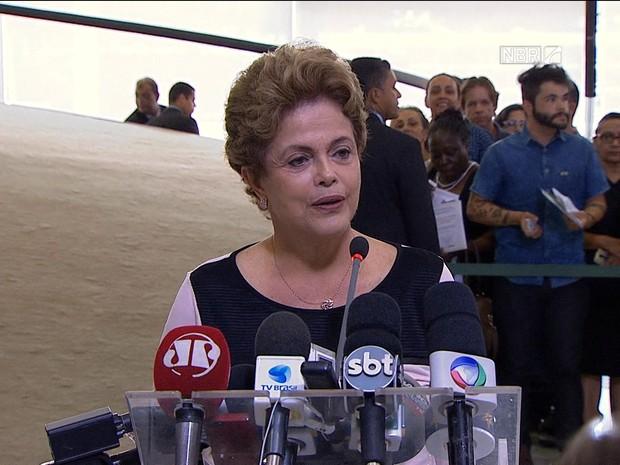 Dilma Rousseff  em púlpito com vários microfones  