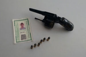 Revólver calibre 32, munição e documento de identidade.