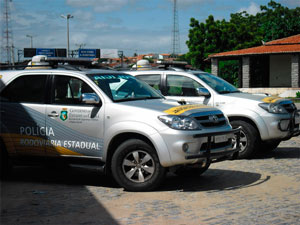 Dois carros da Polícia Rodoviária Estadual estacionados.