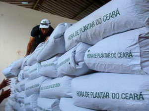 Homem organizando sacos com letreiro impresso Hora de Plantar do Ceará